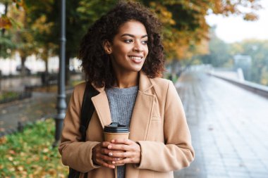 Yürüyüş ceket giyen neşeli genç Afrika kadın