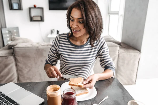 Sorrindo jovem mulher africana tomando café da manhã — Fotografia de Stock