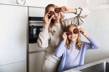 Kapalı ev Mutfak Çerezler gözlerle kapsayan, küçük kız kardeşi olan mutlu kadın.