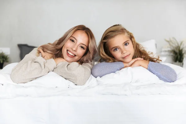 Siostry szczęśliwy dziewcząt na łóżko w sypialni w domu pozowanie uśmiechający się. — Zdjęcie stockowe