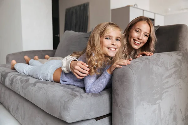 Šťastný, mladá žena se svou mladší sestrou doma doma dívat na televizi. — Stock fotografie