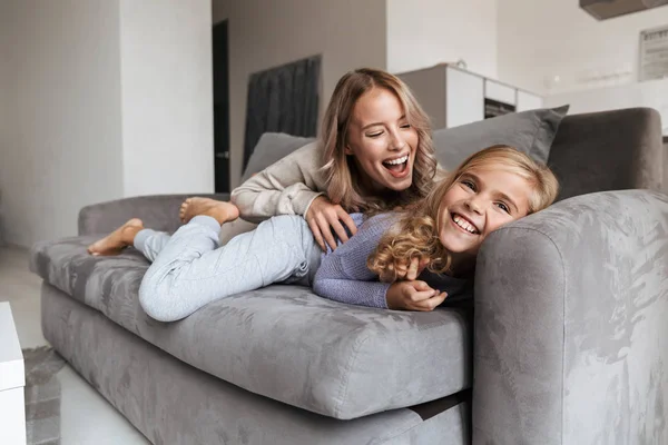 Mutlu genç kadın küçük kız kardeşi kapalı evde tv seyretmek. — Stok fotoğraf
