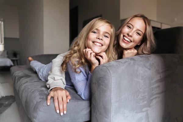 Jovem feliz com sua irmãzinha dentro de casa assistir tv . — Fotografia de Stock