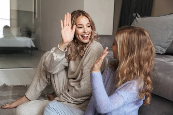 Женщина со своей младшей сестрой в помещении дома дают друг другу пять . — стоковое фото