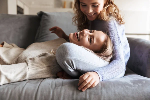 Šťastná mladá žena se svou mladší sestrou doma doma baví. — Stock fotografie