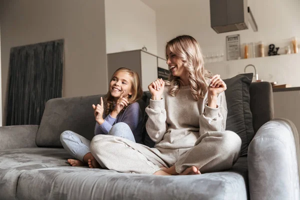 Счастливая молодая женщина со своей младшей сестрой в помещении дома весело . — стоковое фото