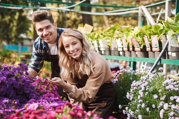 Amazing gardeners posing in the nature greenhouse garden work with flowers plants. — Stock Photo, Image