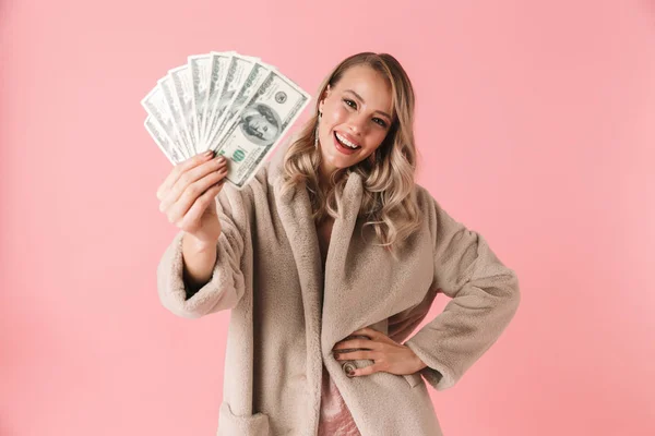 Junge hübsche Frau posiert isoliert über rosa Wand Hintergrund hält Geld. — Stockfoto
