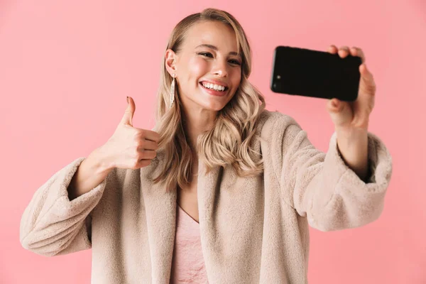 Jovem mulher bonita posando isolado sobre fundo de parede rosa tirar uma selfie por telefone móvel . — Fotografia de Stock