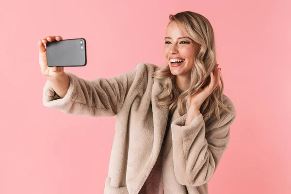 Joven bonita mujer posando aislada sobre fondo de pared rosa tomar una selfie por teléfono móvil . — Foto de Stock