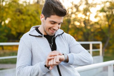 Açık havada duran gülümseyen sağlıklı sporcu