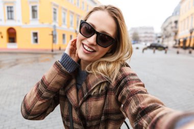 Bir ceket giyen güzel genç sarışın kadın