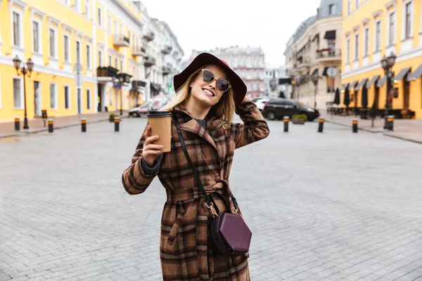 Bella giovane donna bionda che indossa un cappotto a piedi — Foto Stock