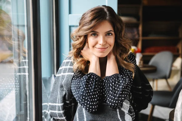 Bella giovane donna coperta di coperta seduta al caffè — Foto Stock