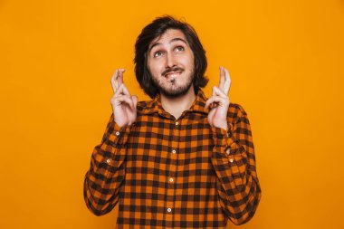 Parmak tutmak ekose gömlek giymiş dua eden genç adam portresi