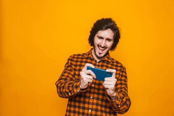 Obraz człowieka uśmiechający się noszenie plaid shirt, grając w gry wideo — Zdjęcie stockowe