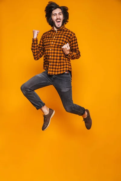 Full length portrait of positive man 20s wearing plaid jumping a — Stock Photo, Image