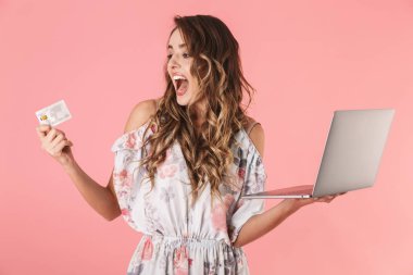 Gümüş laptop ve Mevduat Tasarruf Mevduatı tutan elbiseli genç kadın 20'li yaşlarda fotoğrafı