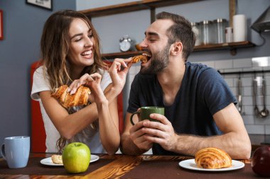 Bre yaparken kruvasan yemek çekici çift portresi