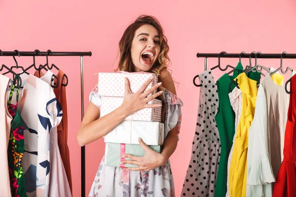 Mulher alegre vestindo vestido de pé na loja perto do rack de roupas — Fotografia de Stock