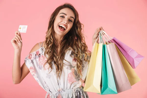 Imagem de mulher alegre 20s em vestido segurando cartão de crédito e cor — Fotografia de Stock