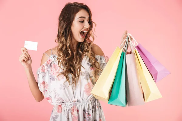 Obrázek hezké ženy 20s v šatech drží kreditní kartu a barvy — Stock fotografie