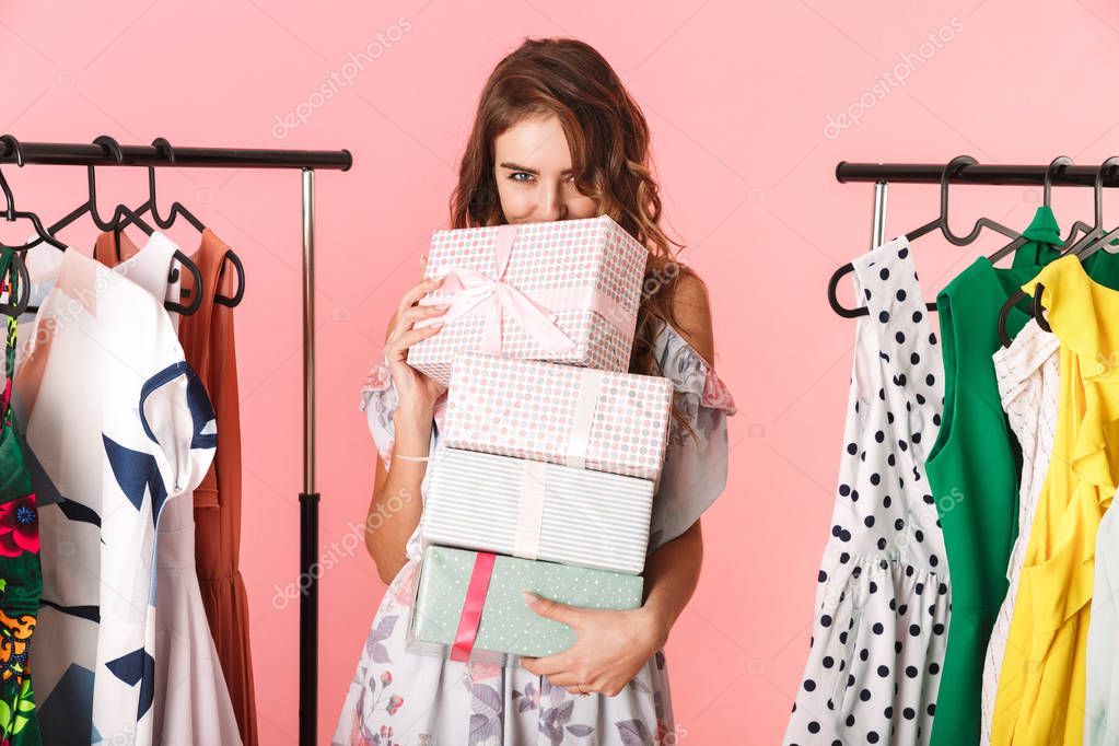 Modest woman wearing dress standing in store near clothes rack w