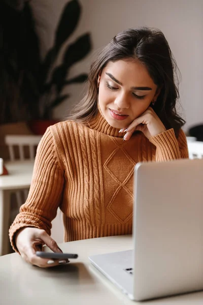 Jolie belle femme assise dans un café à l'intérieur en utilisant un ordinateur portable . — Photo