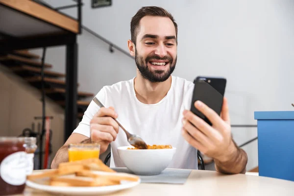 Handsome young man having breakfast — Stock Photo, Image