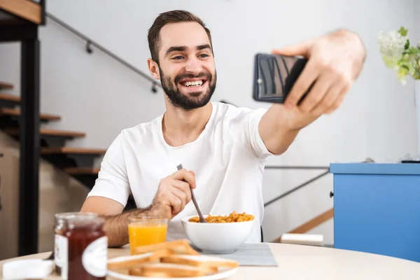 Pohledný mladý muž se snídaní — Stock fotografie