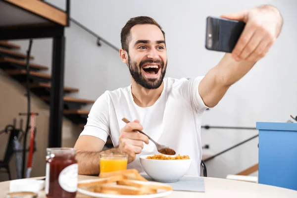 Pohledný mladý muž se snídaní — Stock fotografie