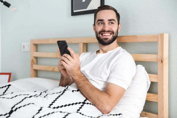 Guapo joven acostado en la cama —  Fotos de Stock