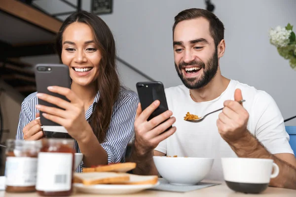 Feliz casal multiétnico tomando café da manhã — Fotografia de Stock