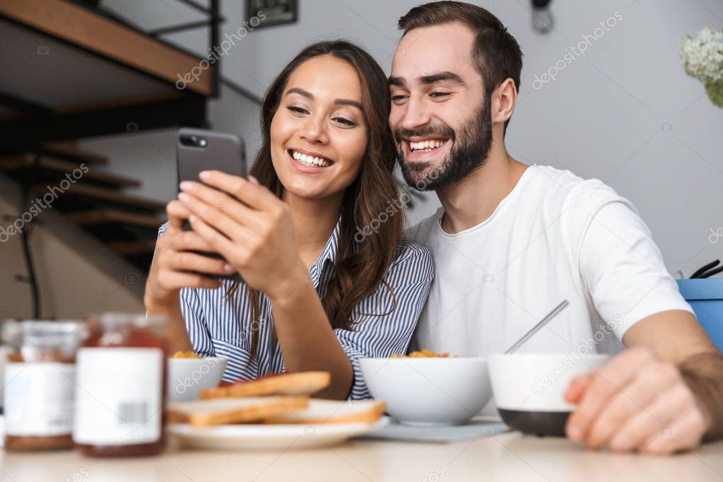 Happy multiethnic couple having breakfast