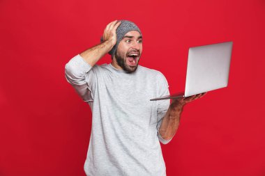 Gümüş dizüstü tutarken sevindirici memnun adam portresi 