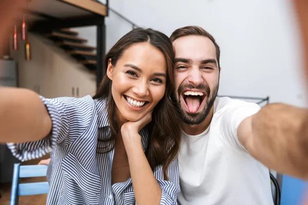 Couple multiethnique joyeux prenant un selfie — Photo