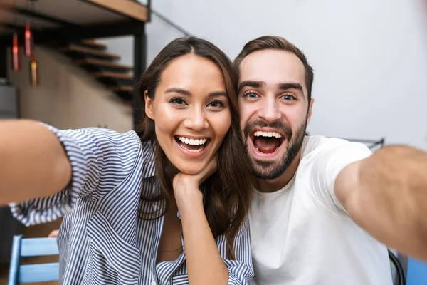 Veselý mnohonárodnostní pár s selfie — Stock fotografie