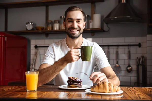 Porträtt av brunett man 30s äta medan du äter frukost i st — Stockfoto