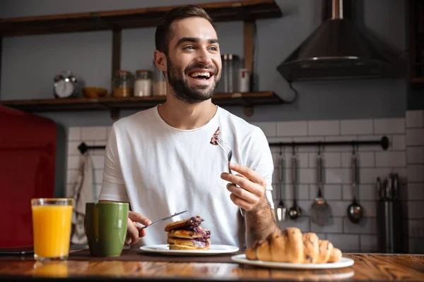 Bilden av kaukasiska kille 30s äta mat medan du äter frukost — Stockfoto
