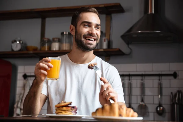 Bilden av ung kille 30s äta mat medan du äter frukost i mod — Stockfoto