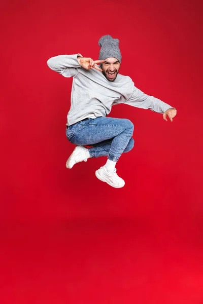 Foto de comprimento total de belo homem sorrindo e pulando isolado — Fotografia de Stock