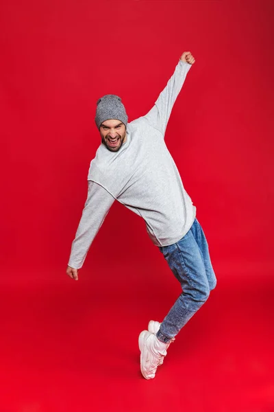 Foto de comprimento total de homem elegante sorrindo e saltando ov isolado — Fotografia de Stock