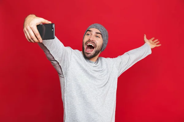 Imagen del hombre positivo riendo mientras toma una foto selfie en la celda — Foto de Stock