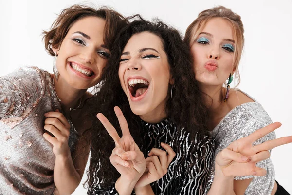 Jóvenes amigas felices posando aisladas sobre fondo blanco de la pared. en una fiesta . —  Fotos de Stock