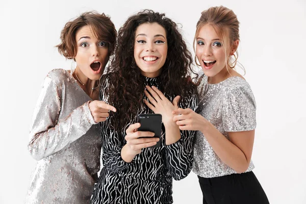 Jóvenes amigas felices posando aisladas sobre fondo blanco de la pared. en una fiesta . — Foto de Stock