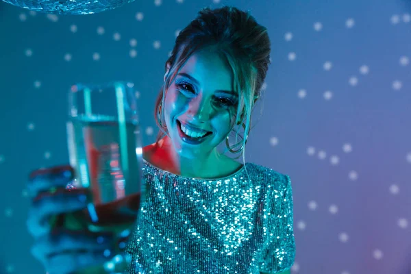Young happy woman posing isolated with disco ball lights holding glass with champagne. — Stock Photo, Image