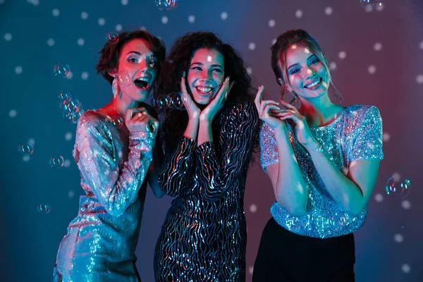 Três mulheres bonitas alegres vestindo roupas brilhantes — Fotografia de Stock