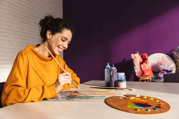 Gülümseyen sanatsal kadın bir palette boya renk seçme — Stok fotoğraf