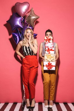 İki mutlu kadınlar 20'li yaşlarda şık kıyafeti presen tutan portresi