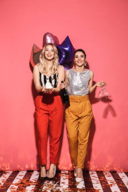 Şık kıyafet Festival tutan iki neşeli kadınlar 20'li yaşlarda fotoğrafı 